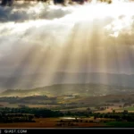 Paesaggio della Valle del Potenza con i raggi del sole che filtrano tra le nuvole grigie